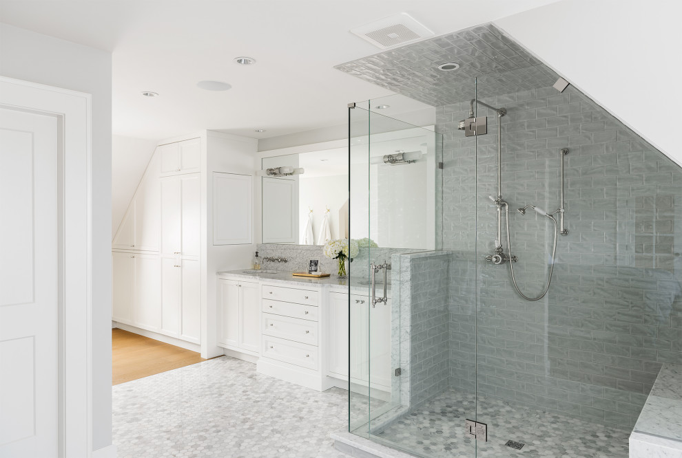 Пример оригинального дизайна: большая главная ванная комната в стиле неоклассика (современная классика) с фасадами в стиле шейкер, белыми фасадами, отдельно стоящей ванной, душем в нише, унитазом-моноблоком, серой плиткой, плиткой кабанчик, белыми стенами, полом из мозаичной плитки, врезной раковиной, мраморной столешницей, серым полом, душем с распашными дверями, серой столешницей, сиденьем для душа, тумбой под две раковины, встроенной тумбой и сводчатым потолком