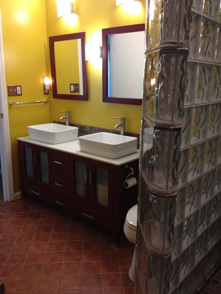 Cette image montre une salle de bain traditionnelle de taille moyenne avec une vasque, une douche ouverte, un carrelage marron, des carreaux de céramique, un mur jaune et un sol en carrelage de céramique.