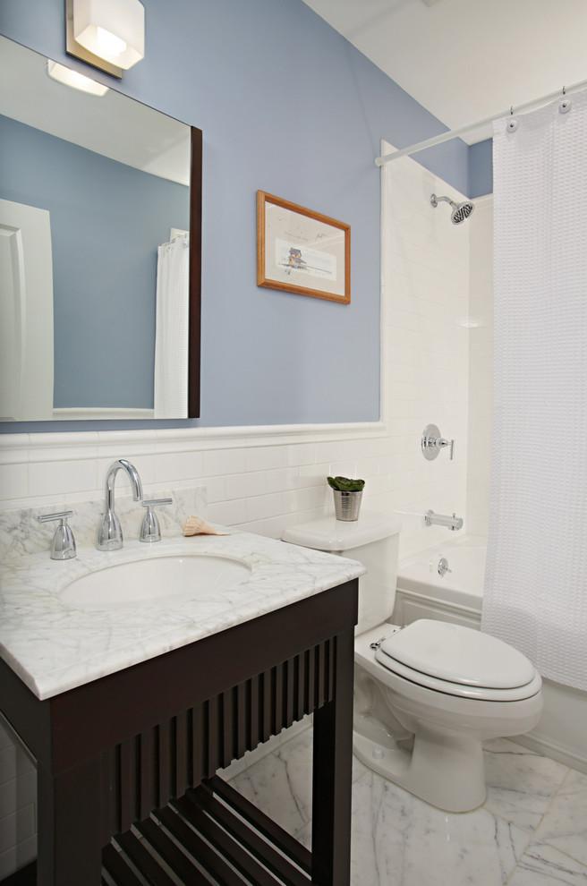 Cette image montre une salle de bain traditionnelle en bois foncé pour enfant avec un placard sans porte, un plan de toilette en marbre et des dalles de pierre.