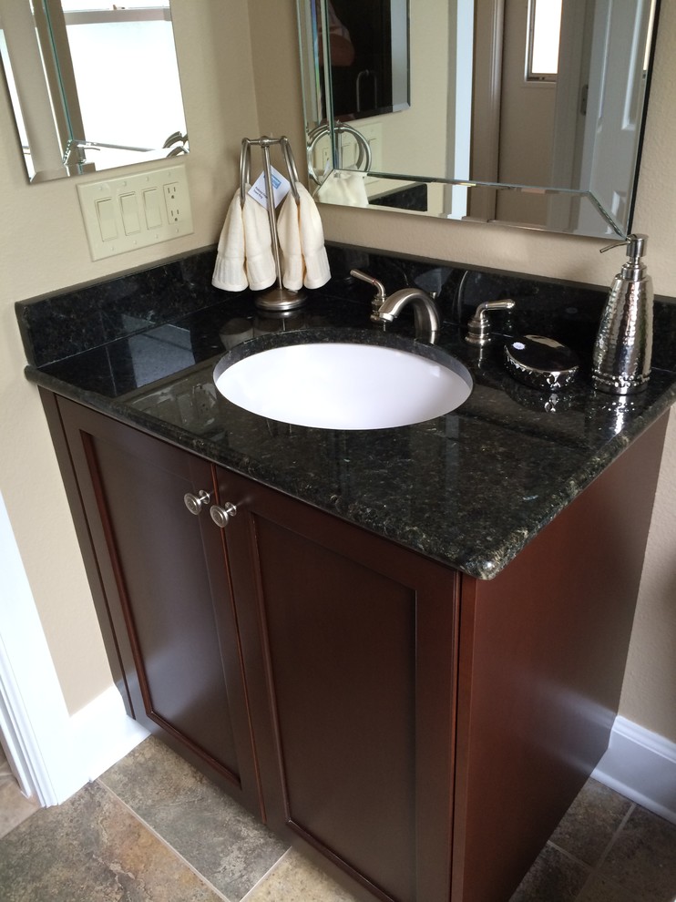 Example of a mid-sized classic 3/4 beige tile travertine floor bathroom design in Tampa with shaker cabinets, dark wood cabinets, a two-piece toilet, beige walls and granite countertops