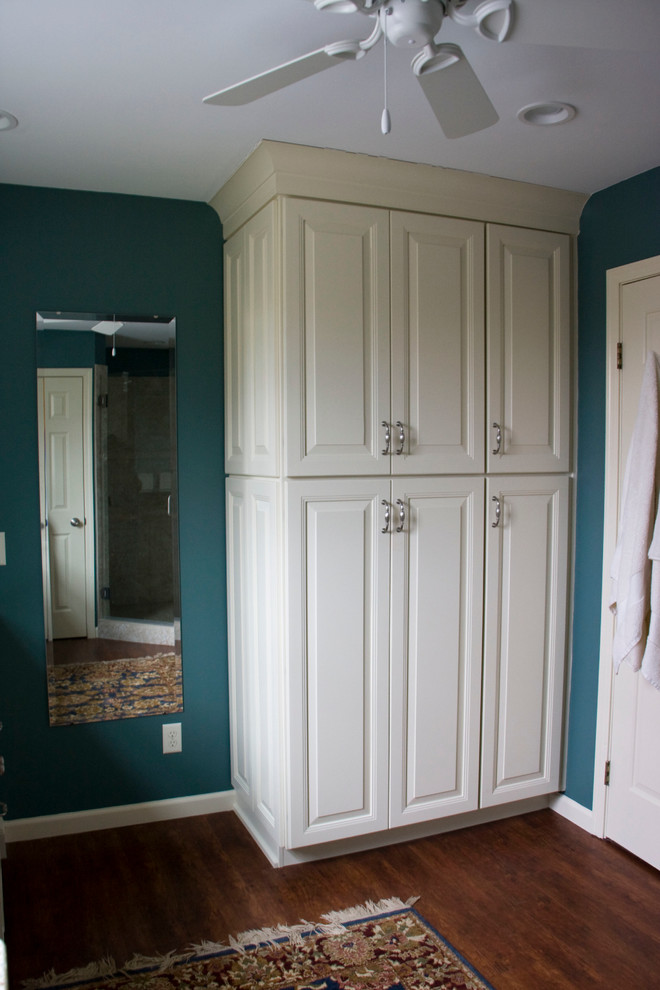 Cette image montre une salle de bain principale traditionnelle de taille moyenne avec un lavabo encastré, un placard avec porte à panneau surélevé, des portes de placard blanches, un plan de toilette en granite, une douche d'angle, un carrelage beige, un carrelage de pierre, un mur bleu et parquet foncé.