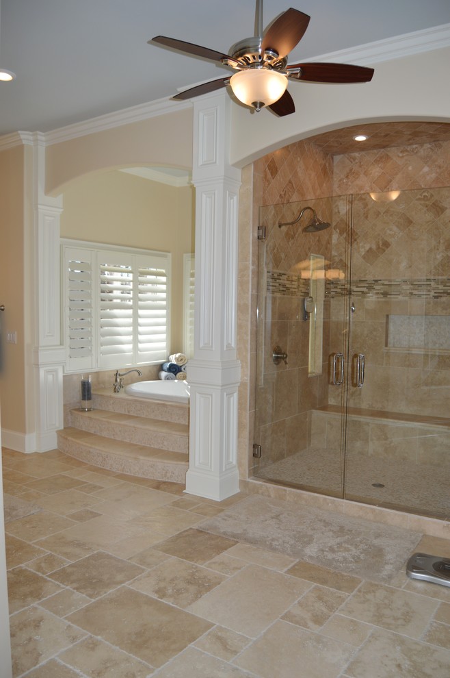 Идея дизайна: большая главная ванная комната в стиле неоклассика (современная классика) с врезной раковиной, фасадами с выступающей филенкой, белыми фасадами, столешницей из известняка, накладной ванной, двойным душем, унитазом-моноблоком, бежевой плиткой, каменной плиткой, бежевыми стенами и полом из известняка
