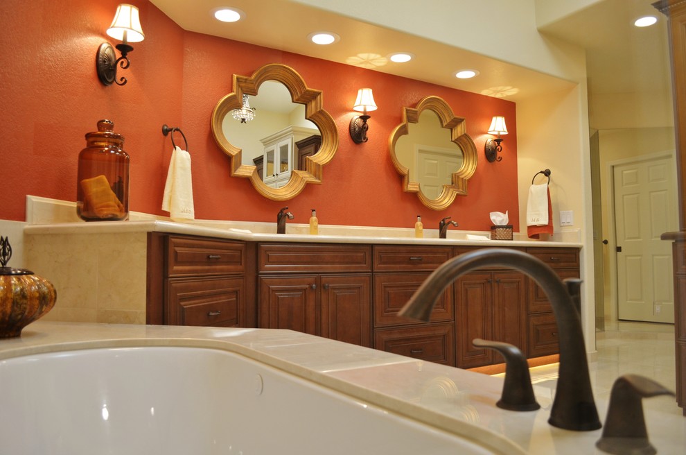 Стильный дизайн: большая главная ванная комната в классическом стиле с врезной раковиной, фасадами с выступающей филенкой, темными деревянными фасадами, мраморной столешницей, полновстраиваемой ванной, двойным душем, биде, бежевой плиткой, каменной плиткой, оранжевыми стенами и полом из керамогранита - последний тренд