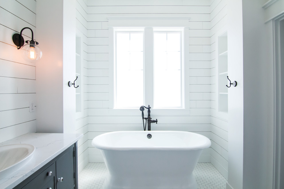 Bild på ett mellanstort lantligt en-suite badrum, med möbel-liknande, blå skåp, ett fristående badkar, en dusch i en alkov, en toalettstol med separat cisternkåpa, vita väggar, klinkergolv i keramik, ett fristående handfat, bänkskiva i kvarts, vitt golv och med dusch som är öppen