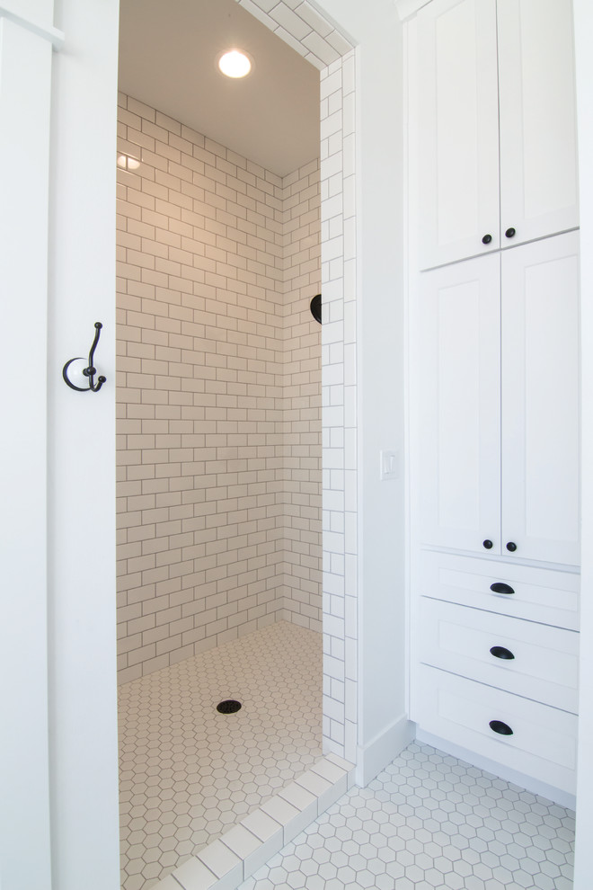 This is an example of a medium sized country ensuite bathroom in Seattle with freestanding cabinets, blue cabinets, a freestanding bath, an alcove shower, a two-piece toilet, white tiles, ceramic tiles, white walls, ceramic flooring, a vessel sink, engineered stone worktops, white floors and an open shower.