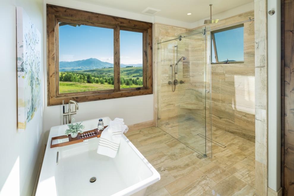 Inredning av ett klassiskt mellanstort en-suite badrum, med ett fristående badkar, en kantlös dusch, brun kakel, travertinkakel, bruna väggar, travertin golv, brunt golv och dusch med skjutdörr