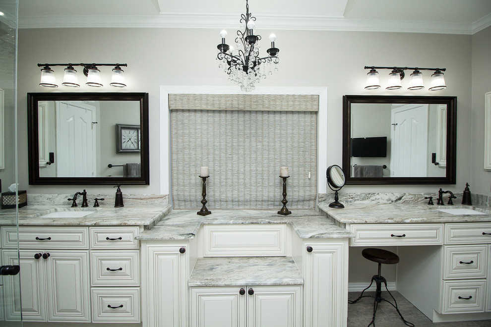 Inspiration for a medium sized traditional ensuite bathroom in Houston with raised-panel cabinets, white cabinets, an alcove shower, grey tiles, porcelain tiles, grey walls, porcelain flooring, a submerged sink, granite worktops, grey floors and a hinged door.