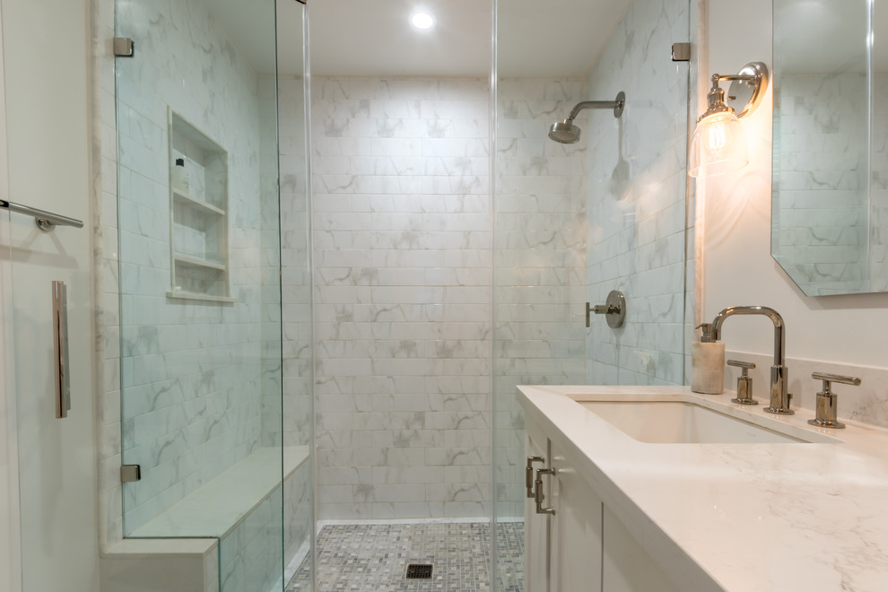 Inredning av ett modernt mellanstort vit vitt badrum med dusch, med skåp i shakerstil, vita skåp, en dusch i en alkov, en toalettstol med separat cisternkåpa, grå kakel, marmorkakel, grå väggar, ett undermonterad handfat, marmorbänkskiva och dusch med gångjärnsdörr