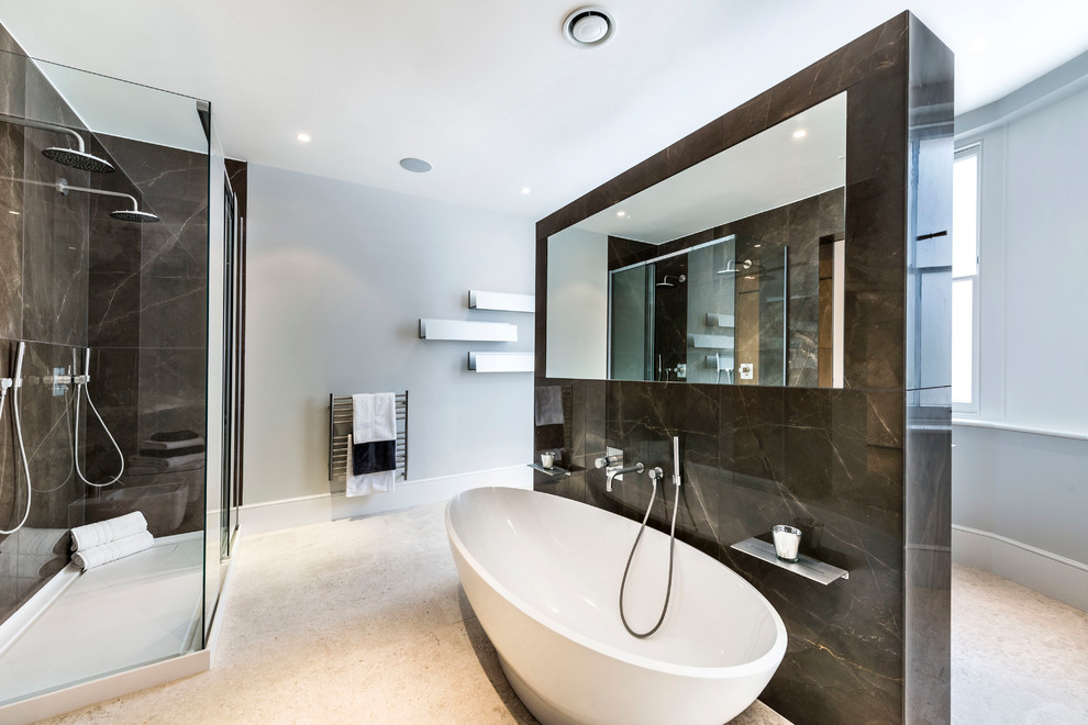 ロンドンにあるトランジショナルスタイルのおしゃれなマスターバスルーム (置き型浴槽、ダブルシャワー、茶色いタイル、グレーの壁) の写真