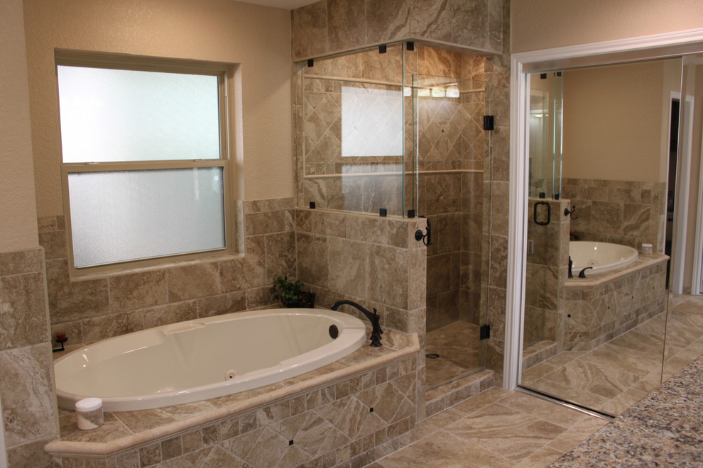 Modelo de cuarto de baño clásico renovado con bañera encastrada, ducha empotrada, baldosas y/o azulejos beige y paredes beige