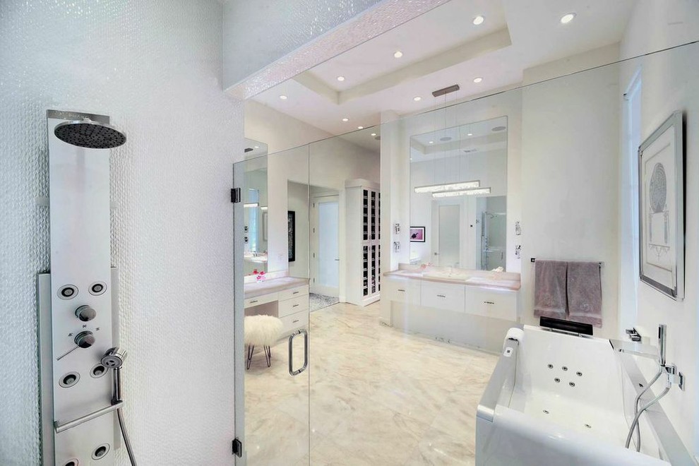 Immagine di una grande stanza da bagno padronale minimalista con ante lisce, ante bianche, vasca freestanding, WC monopezzo, piastrelle bianche e pareti bianche