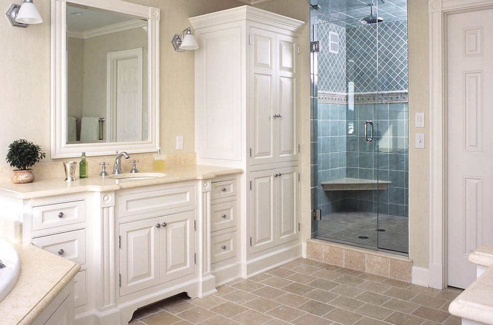 Пример оригинального дизайна: главная ванная комната среднего размера в стиле неоклассика (современная классика) с белыми фасадами, унитазом-моноблоком, каменной плиткой, фасадами с выступающей филенкой, накладной ванной, бежевыми стенами, полом из известняка, врезной раковиной, двойным душем, синей плиткой, мраморной столешницей, бежевым полом и душем с распашными дверями