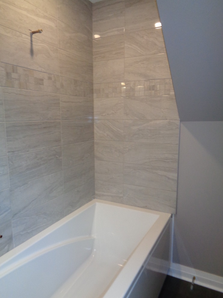 This is an example of a small traditional bathroom in San Diego with a shower/bath combination, grey tiles, stone tiles, grey walls and dark hardwood flooring.