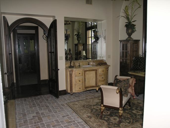 На фото: большая ванная комната в средиземноморском стиле с накладной раковиной, светлыми деревянными фасадами, белыми стенами, кирпичным полом и коричневым полом