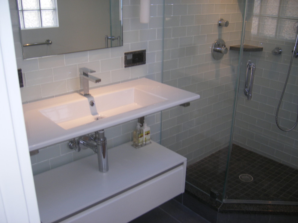Mid-sized transitional 3/4 green tile and glass tile ceramic tile and gray floor corner shower photo in DC Metro with open cabinets, white cabinets, a one-piece toilet, an integrated sink, solid surface countertops and a hinged shower door