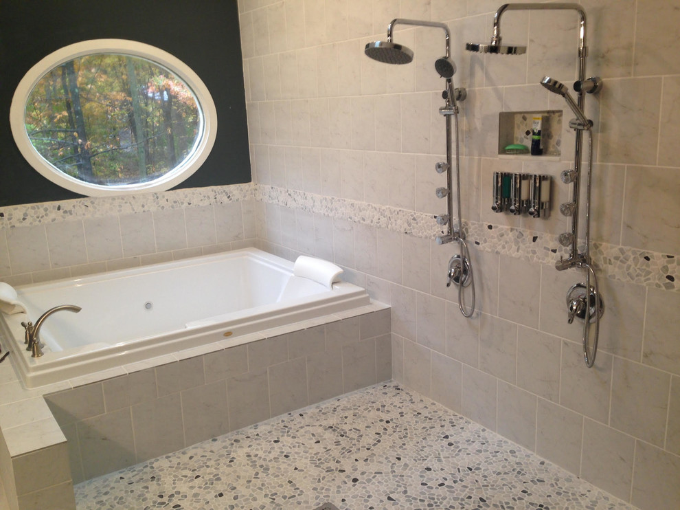 Cette photo montre une salle de bain principale chic de taille moyenne avec une baignoire posée, un espace douche bain, un carrelage gris, un carrelage blanc, un carrelage de pierre, un mur noir, un sol en galet et un sol multicolore.