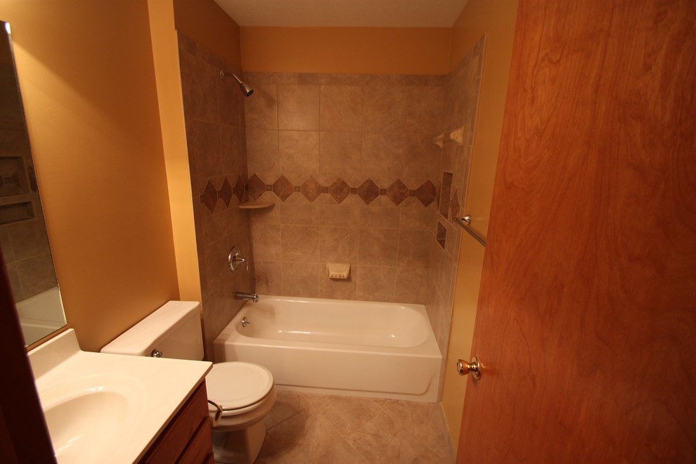 Aménagement d'une salle de bain principale classique en bois foncé avec un lavabo encastré, un placard avec porte à panneau surélevé, un plan de toilette en granite, une douche d'angle, WC à poser, un carrelage marron, un carrelage de pierre, un mur beige, tomettes au sol, un sol gris et une cabine de douche à porte battante.