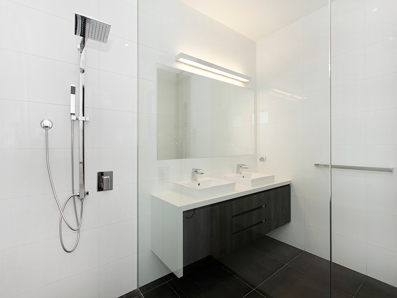 Foto de cuarto de baño actual con puertas de armario negras, baldosas y/o azulejos negros, paredes blancas y suelo de baldosas de cerámica