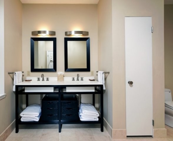Idéer för att renovera ett mellanstort funkis badrum med dusch, med släta luckor, svarta skåp, ett hörnbadkar, en hörndusch, en toalettstol med hel cisternkåpa, vit kakel, stenhäll, beige väggar, klinkergolv i keramik, ett undermonterad handfat och bänkskiva i akrylsten