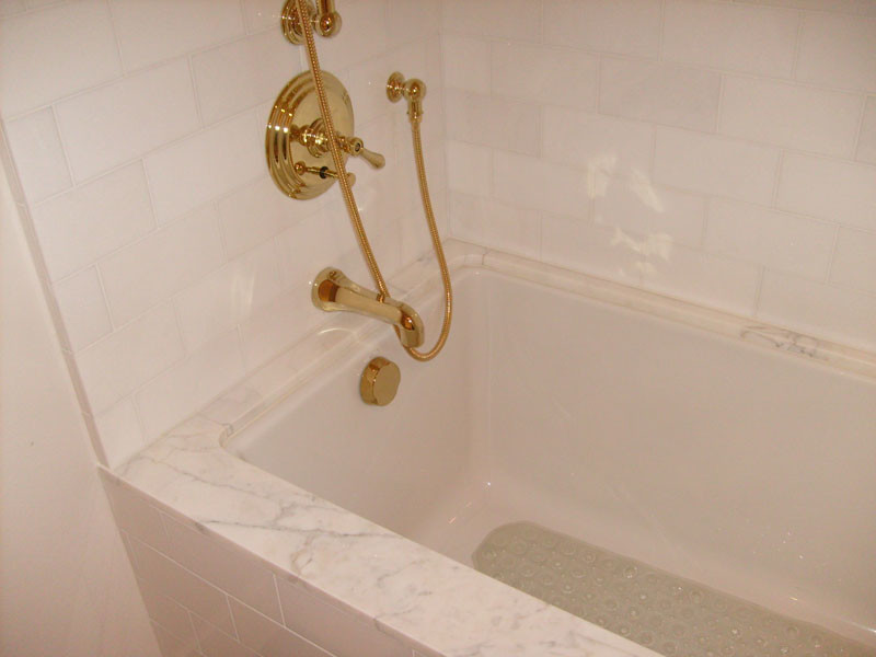 Example of a large classic master white tile porcelain tile tub/shower combo design in Houston with white walls, recessed-panel cabinets, white cabinets, a drop-in sink and marble countertops