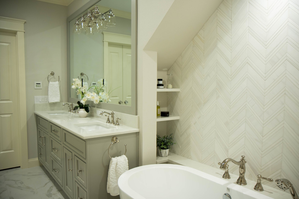 Idéer för ett mellanstort klassiskt vit en-suite badrum, med luckor med infälld panel, grå skåp, ett fristående badkar, grå kakel, marmorkakel, grå väggar, klinkergolv i porslin, ett undermonterad handfat, bänkskiva i kvartsit och vitt golv