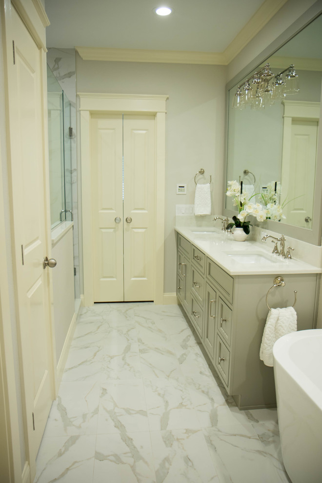 Inspiration för ett mellanstort vintage vit vitt en-suite badrum, med luckor med infälld panel, grå skåp, ett fristående badkar, grå kakel, marmorkakel, grå väggar, klinkergolv i porslin, ett undermonterad handfat, bänkskiva i kvartsit och vitt golv