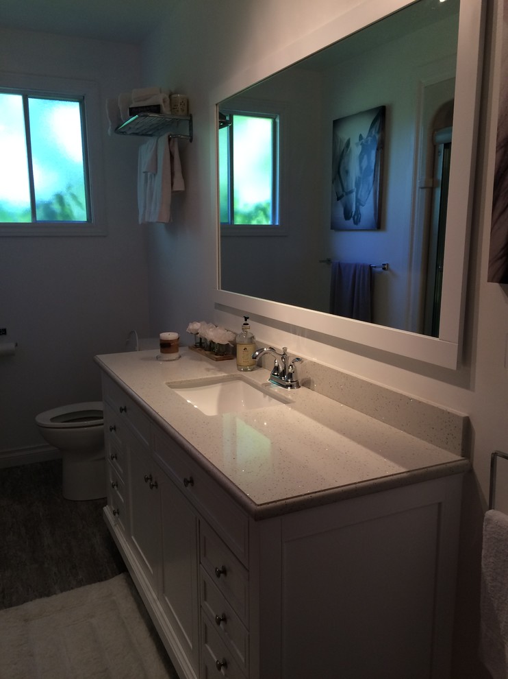 Example of a small master bathroom design in Toronto with white cabinets and solid surface countertops