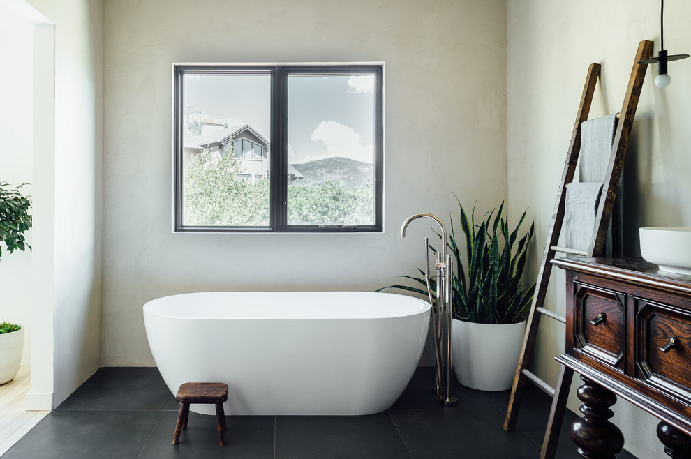 Cette photo montre une salle de bain principale éclectique de taille moyenne avec une baignoire indépendante, une douche ouverte, WC à poser, un carrelage rose, des carreaux de béton, un mur gris, un sol en carrelage de céramique, un lavabo de ferme et un sol noir.