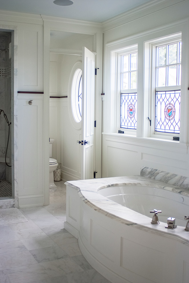 Cette image montre une salle de bain principale traditionnelle avec une baignoire encastrée, un mur blanc et une fenêtre.