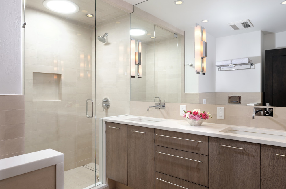 Exempel på ett mellanstort modernt badrum med dusch, med ett undermonterad handfat, släta luckor, skåp i mellenmörkt trä, en hörndusch, beige kakel och vita väggar