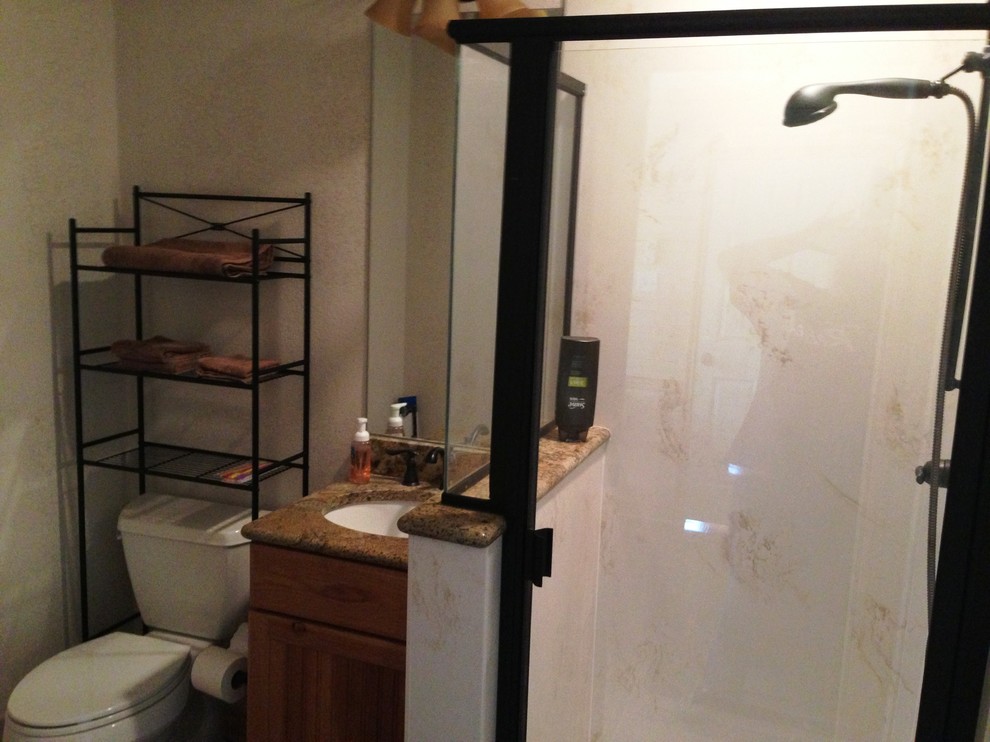 Imagen de cuarto de baño principal tradicional pequeño con lavabo bajoencimera, armarios estilo shaker, puertas de armario de madera clara, encimera de granito, ducha esquinera, sanitario de dos piezas y paredes beige