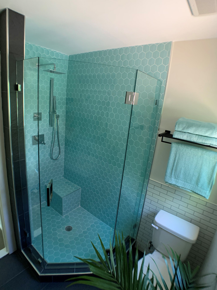 Photo of a medium sized modern ensuite bathroom in DC Metro with freestanding cabinets, dark wood cabinets, a corner shower, green tiles, ceramic tiles, white walls, laminate floors, an integrated sink, brown floors, a hinged door, a single sink and a built in vanity unit.