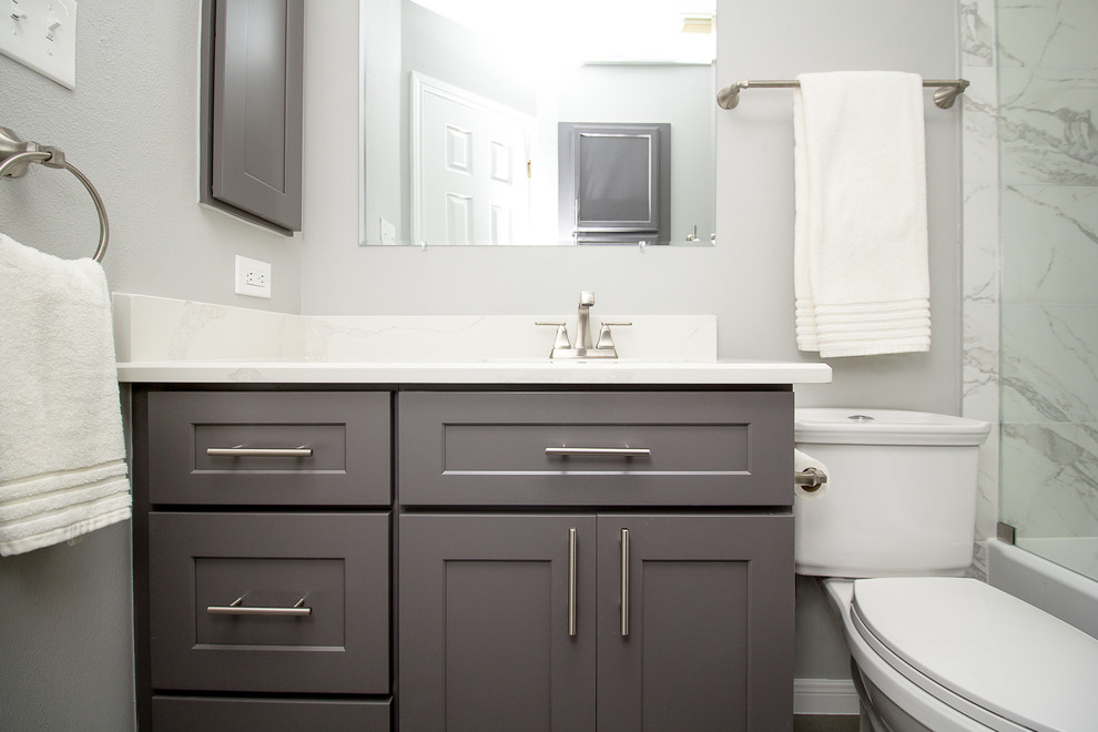Bild på ett litet vintage badrum med dusch, med skåp i shakerstil, grå skåp, ett badkar i en alkov, en dusch/badkar-kombination, vit kakel, porslinskakel, grå väggar, klinkergolv i porslin, ett undermonterad handfat, bänkskiva i kvarts, grått golv och dusch med skjutdörr