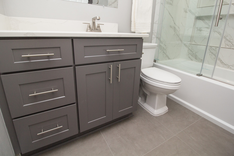 Inredning av ett klassiskt litet badrum med dusch, med skåp i shakerstil, grå skåp, ett badkar i en alkov, en dusch/badkar-kombination, vit kakel, porslinskakel, grå väggar, klinkergolv i porslin, ett undermonterad handfat, bänkskiva i kvarts, grått golv och dusch med skjutdörr