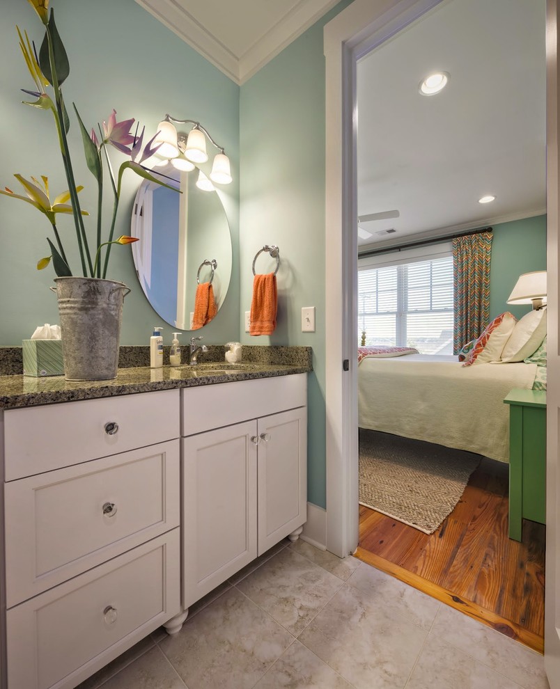 Mittelgroßes Maritimes Badezimmer mit Schrankfronten mit vertiefter Füllung, weißen Schränken, grüner Wandfarbe, Travertin, Unterbauwaschbecken und Granit-Waschbecken/Waschtisch in Charleston