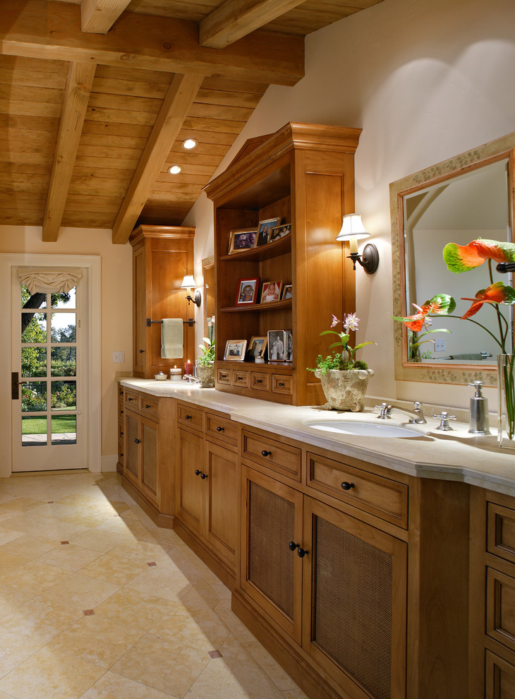 На фото: ванная комната в средиземноморском стиле с врезной раковиной, фасадами с утопленной филенкой и фасадами цвета дерева среднего тона с