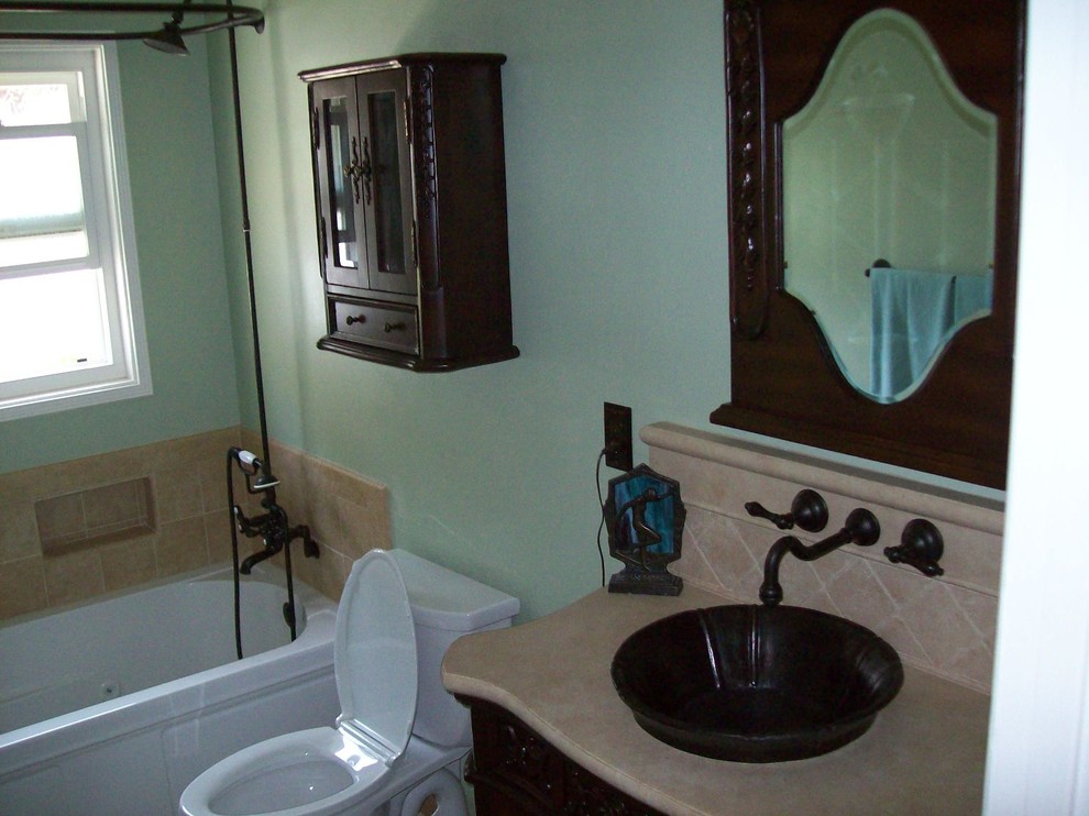 Cette image montre une salle de bain principale traditionnelle en bois foncé de taille moyenne avec un lavabo suspendu, un placard en trompe-l'oeil, un plan de toilette en calcaire, une baignoire en alcôve, un combiné douche/baignoire, WC séparés, un carrelage beige, des carreaux de porcelaine, un mur vert et un sol en carrelage de porcelaine.