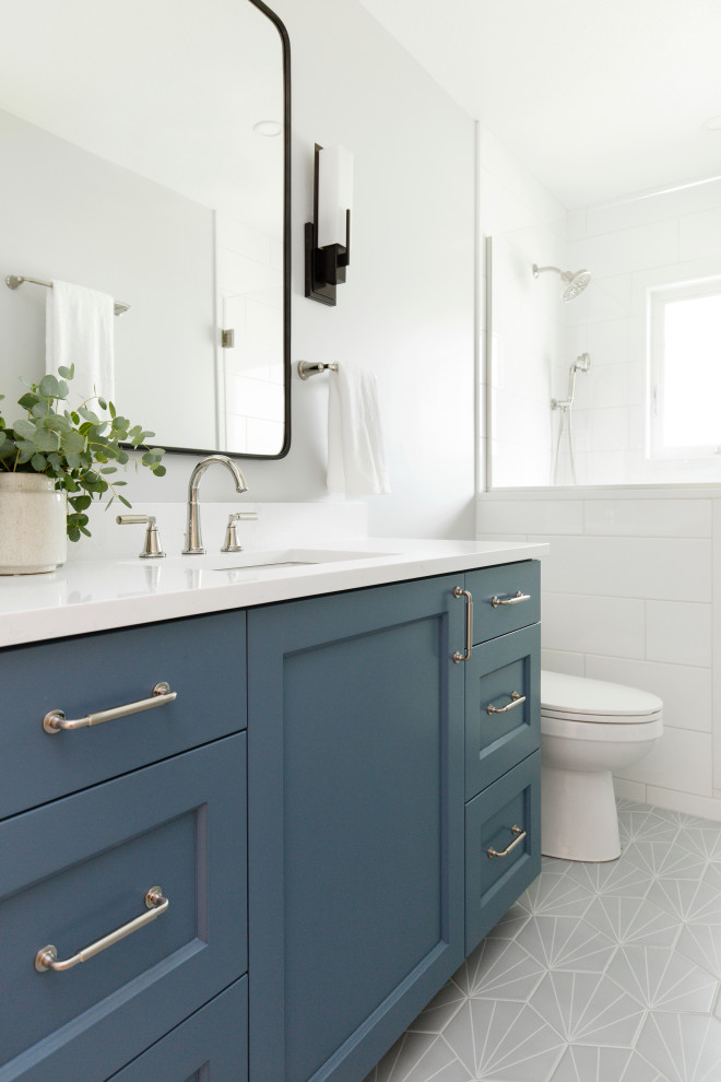 Idéer för ett mellanstort klassiskt vit en-suite badrum, med luckor med infälld panel, blå skåp, en dusch i en alkov, en toalettstol med separat cisternkåpa, vit kakel, keramikplattor, grå väggar, klinkergolv i porslin, ett undermonterad handfat, bänkskiva i kvarts, grått golv och dusch med gångjärnsdörr