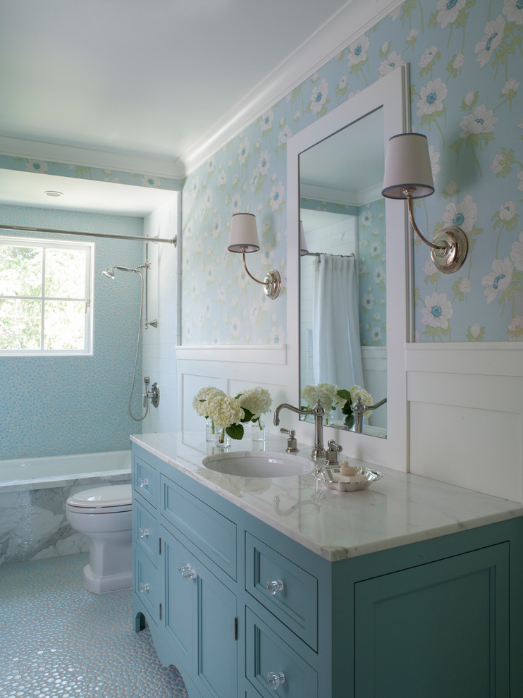 Lantlig inredning av ett vit vitt badrum med dusch, med luckor med infälld panel, blå skåp, ett badkar i en alkov, en dusch/badkar-kombination, vit kakel, tunnelbanekakel, blå väggar, ett undermonterad handfat, blått golv och dusch med duschdraperi