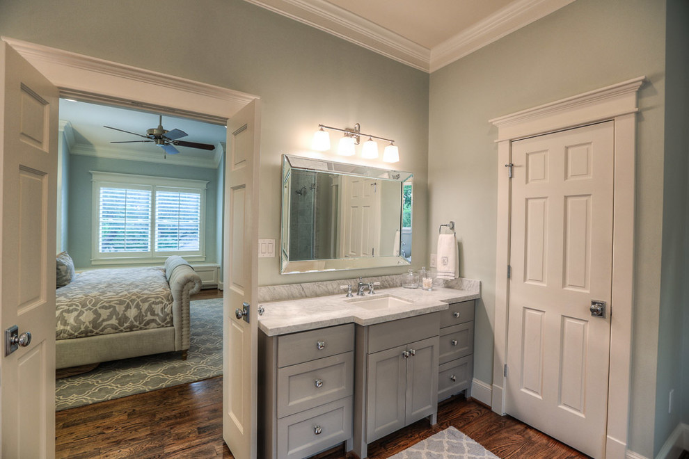 Amerikansk inredning av ett stort en-suite badrum, med ett undermonterad handfat, skåp i shakerstil, grå skåp, marmorbänkskiva, ett fristående badkar, grå väggar och mörkt trägolv