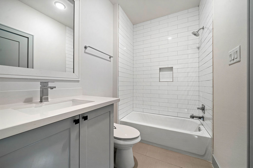 Mid-sized transitional kids' white tile and ceramic tile porcelain tile and gray floor bathroom photo in Houston with furniture-like cabinets, gray cabinets, a one-piece toilet, white walls, a drop-in sink, quartz countertops and white countertops
