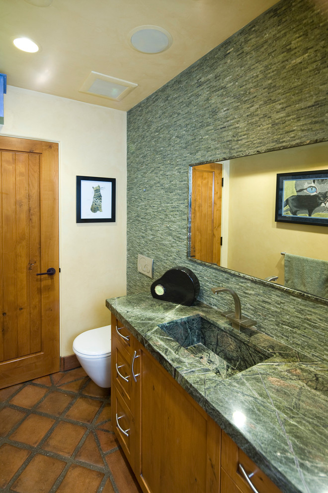 This is an example of an eclectic bathroom in Santa Barbara with an integrated sink, shaker cabinets, medium wood cabinets, a bidet, green tiles, stone tiles, granite worktops, beige walls and terracotta flooring.