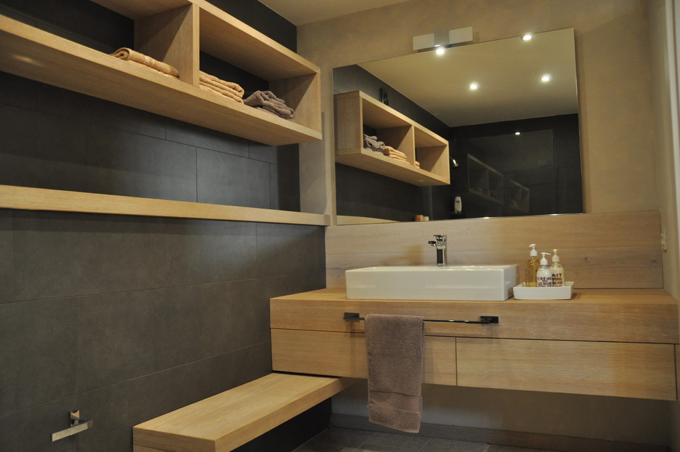 Mittelgroßes Modernes Duschbad mit hellen Holzschränken, offener Dusche, Wandtoilette, Keramikfliesen, beiger Wandfarbe, Travertin und Aufsatzwaschbecken in Sonstige