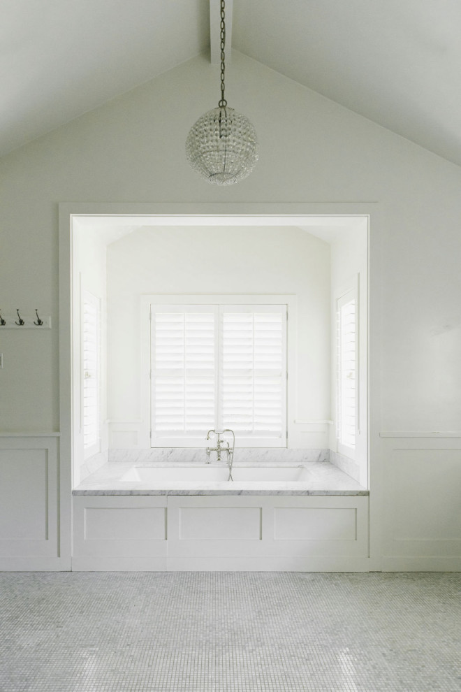 Drop-in bathtub - large country master white tile and marble tile porcelain tile, white floor, double-sink, vaulted ceiling and wall paneling drop-in bathtub idea in Los Angeles with white walls, marble countertops and white countertops