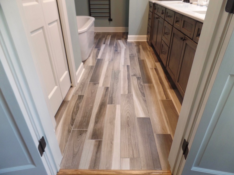 Example of a mid-sized transitional master gray tile and porcelain tile porcelain tile bathroom design in Other with shaker cabinets, distressed cabinets, a two-piece toilet, green walls, an undermount sink and quartz countertops