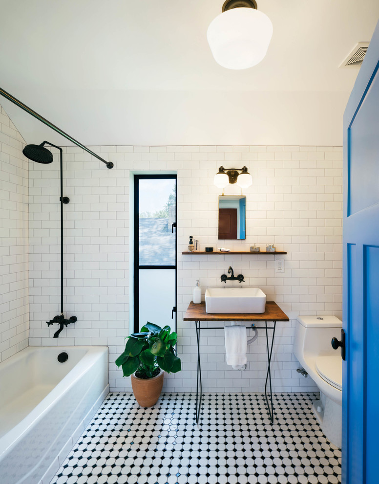 Cette photo montre une salle de bain tendance de taille moyenne avec un combiné douche/baignoire, WC à poser, un carrelage blanc, des carreaux de céramique et un mur blanc.