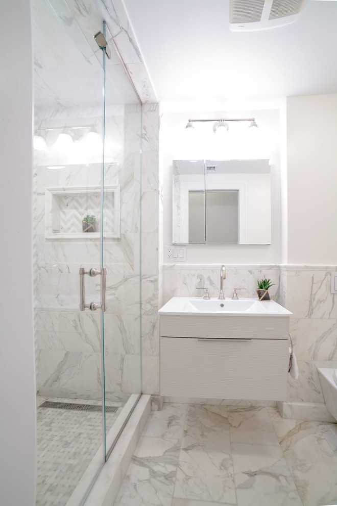 Inredning av ett modernt litet vit vitt en-suite badrum, med släta luckor, vita skåp, en dusch i en alkov, en vägghängd toalettstol, vit kakel, marmorkakel, blå väggar, marmorgolv, ett undermonterad handfat, marmorbänkskiva, vitt golv och med dusch som är öppen