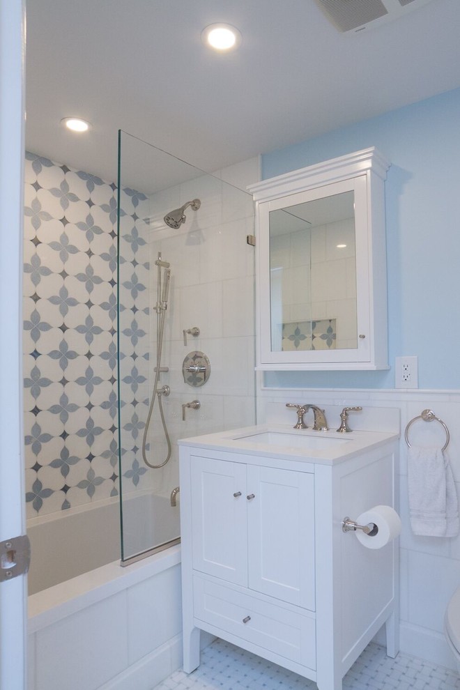 Idéer för att renovera ett litet funkis vit vitt badrum för barn, med skåp i shakerstil, vita skåp, ett undermonterat badkar, en dusch/badkar-kombination, en vägghängd toalettstol, vit kakel, marmorkakel, blå väggar, mosaikgolv, ett undermonterad handfat, marmorbänkskiva, vitt golv och med dusch som är öppen
