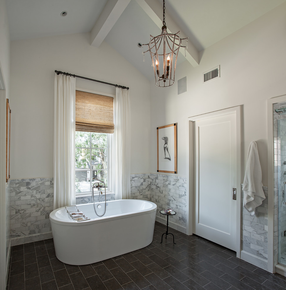 Foto di una stanza da bagno padronale country con vasca freestanding, doccia alcova, piastrelle grigie, pareti multicolore, pavimento nero e porta doccia a battente