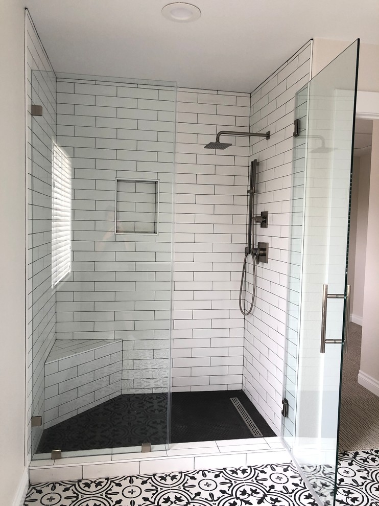 Inspiration for a large transitional master white tile and subway tile ceramic tile and multicolored floor bathroom remodel in Las Vegas with shaker cabinets, brown cabinets, a one-piece toilet, white walls, an undermount sink, quartz countertops, a hinged shower door and multicolored countertops